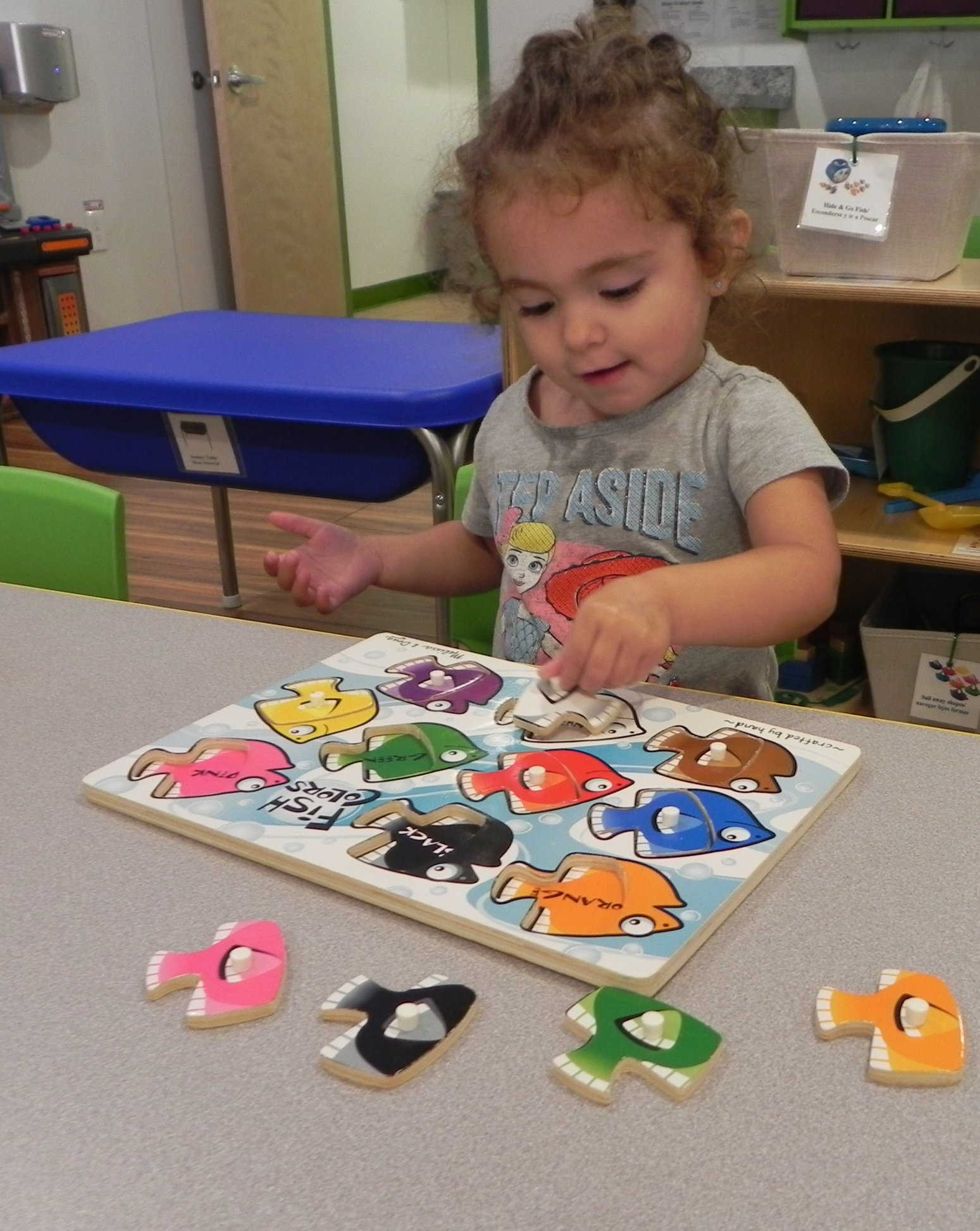Two year old girl doing puzzle